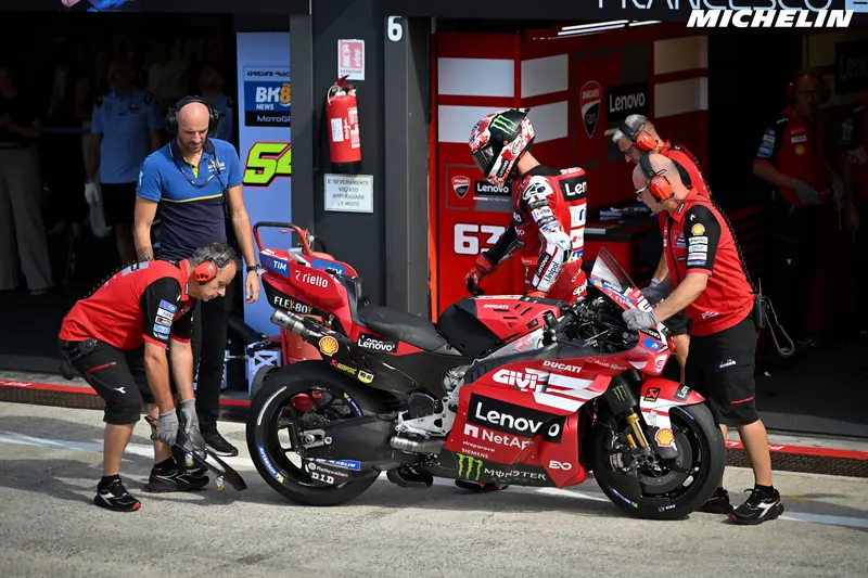 Francesco Bagnaia rentre au stand Ducati, sa moto numéro 63 tenue par ses mécaniciens