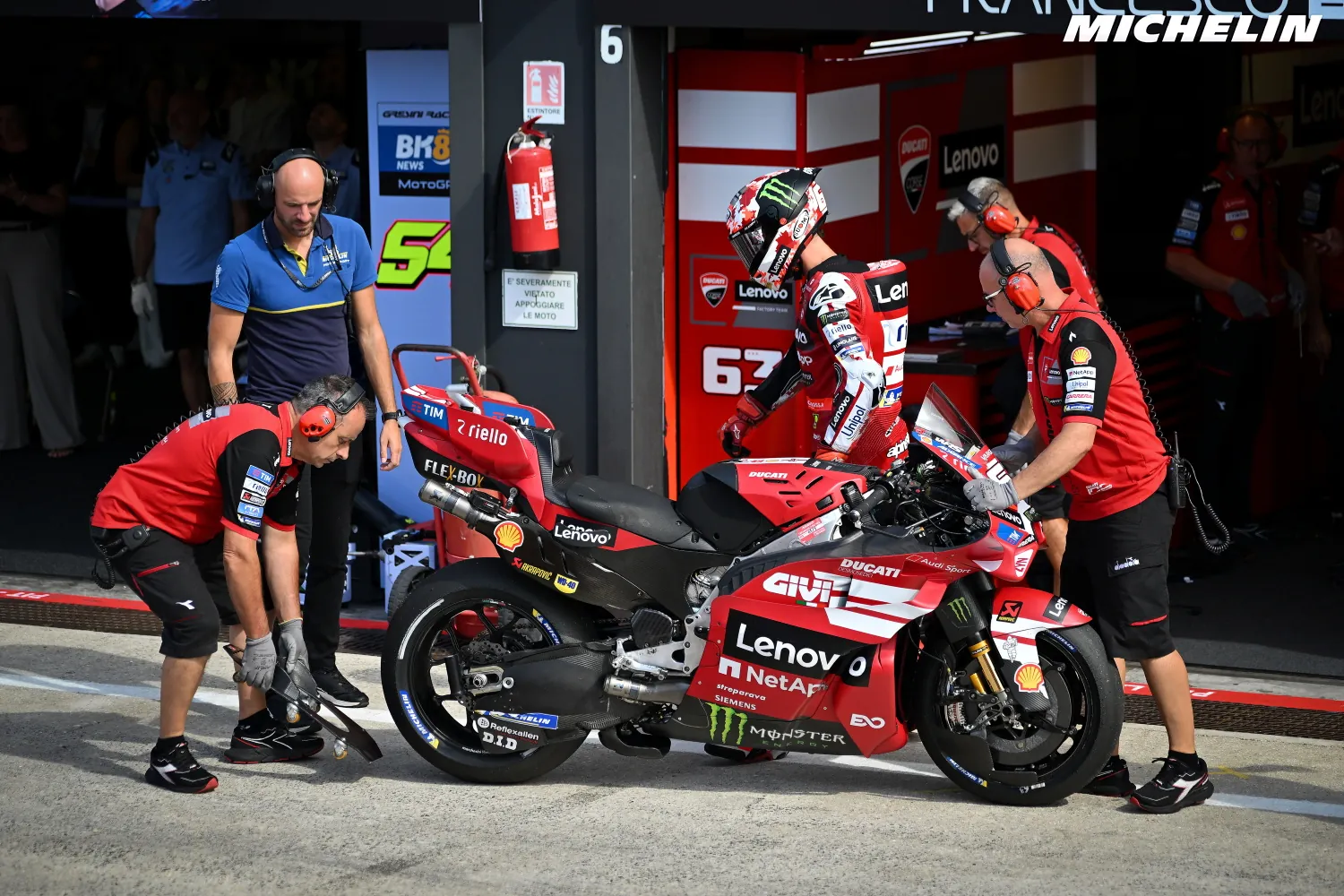 Francesco Bagnaia rentre au stand Ducati, sa moto numéro 63 tenue par ses mécaniciens