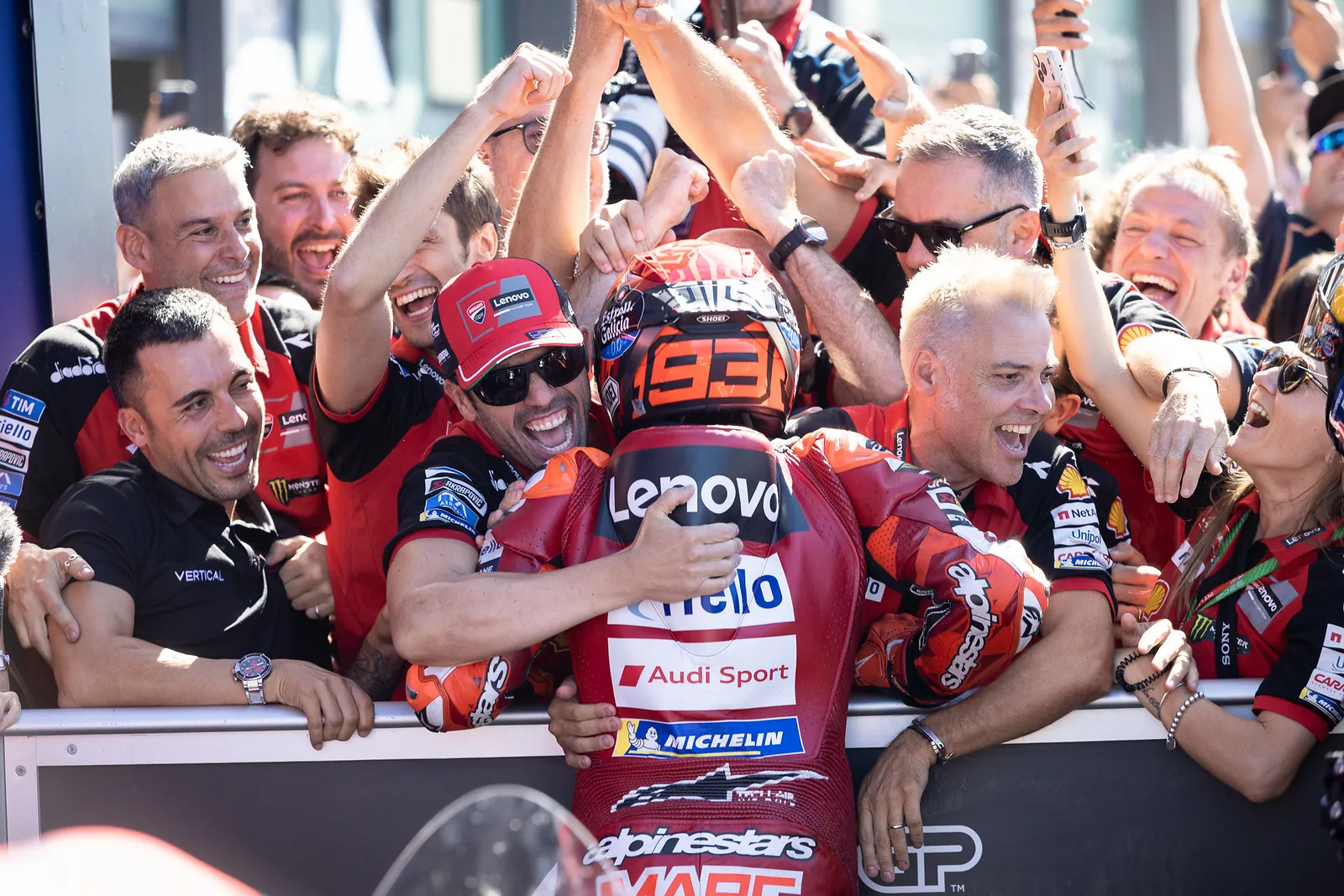 Marc Márquez, de dos, fête sa victoire avec son équipe Ducati derrière la barrière