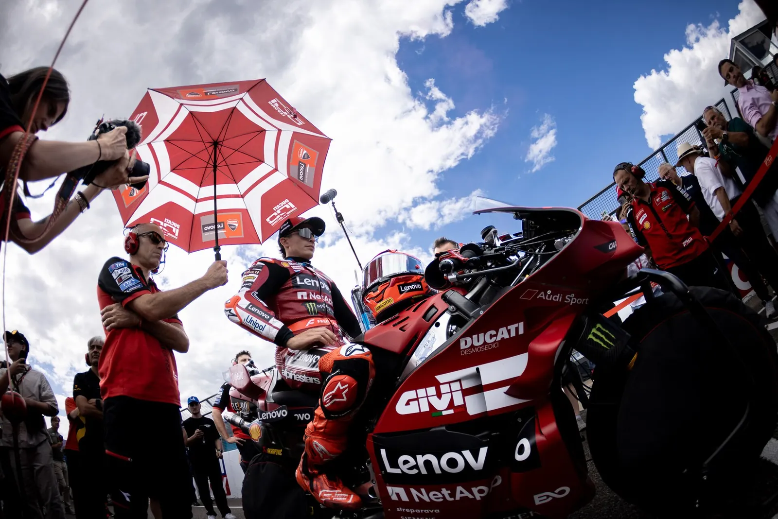 Marc Márquez sur la grille, à côté de sa Ducati et d’un parapluie